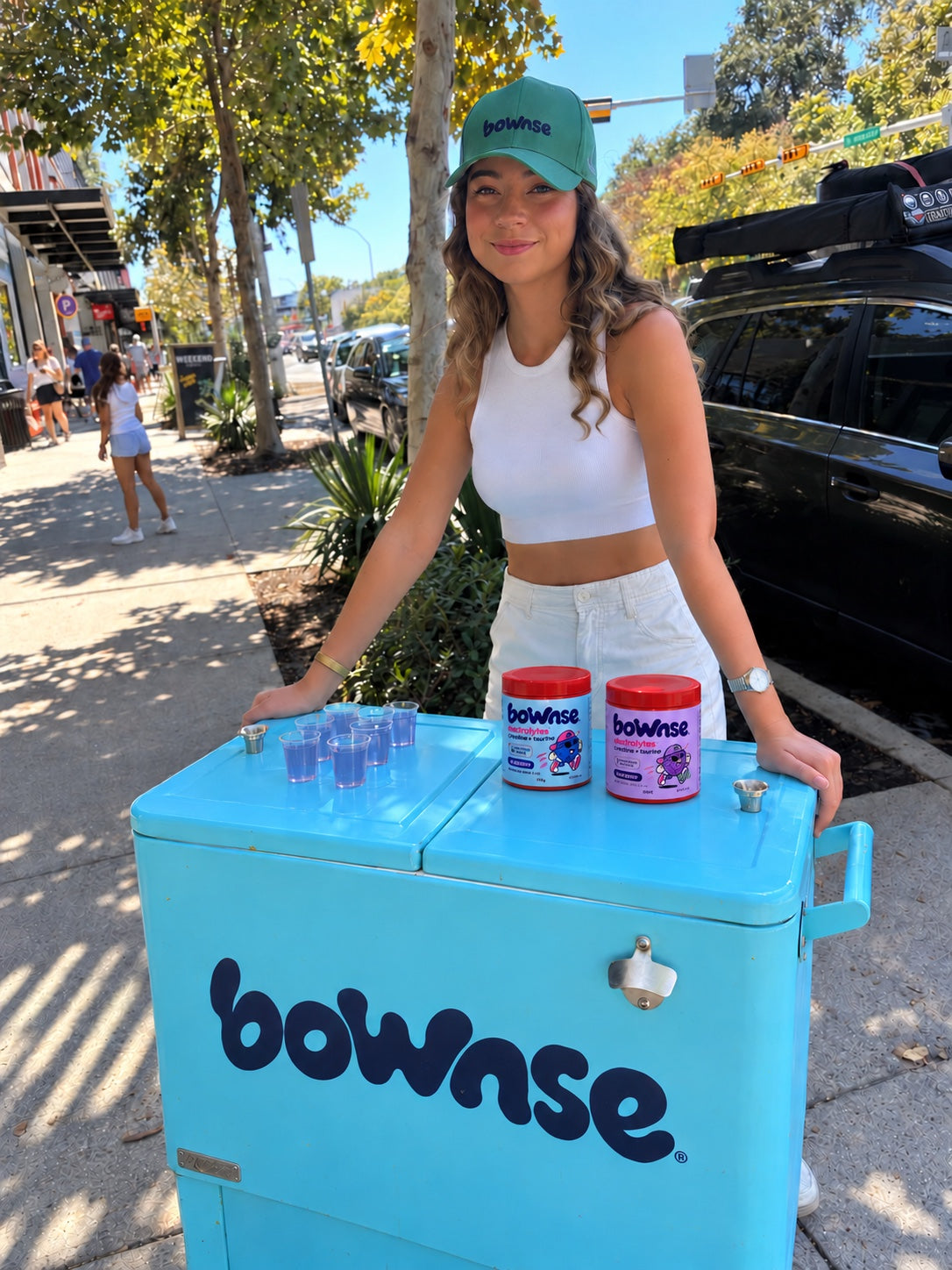 Woman beside a blue BOWNSE cart with Blueberry and Grape tubs